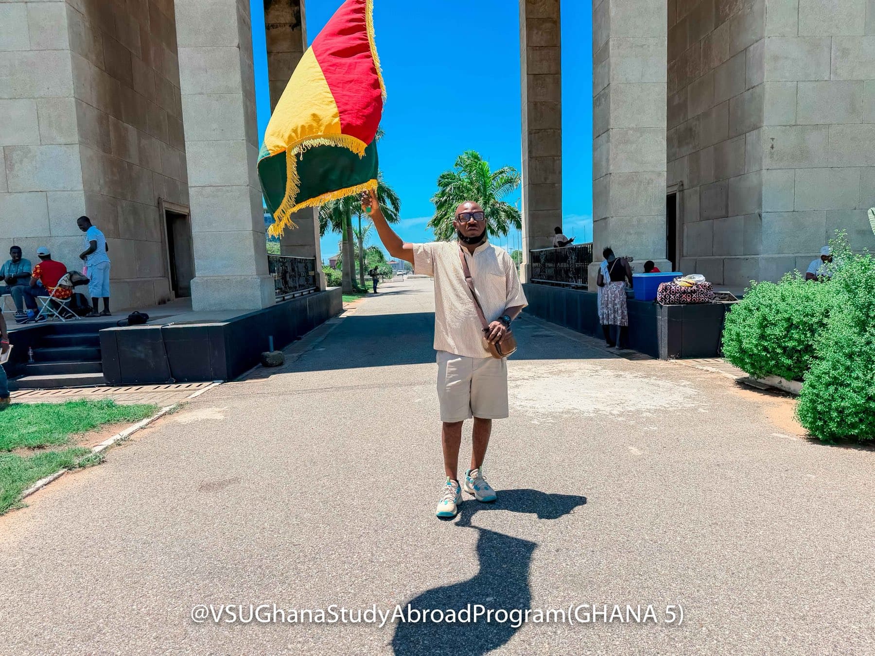 A guide raising the Ghanaian flag beneath the Independence Arch