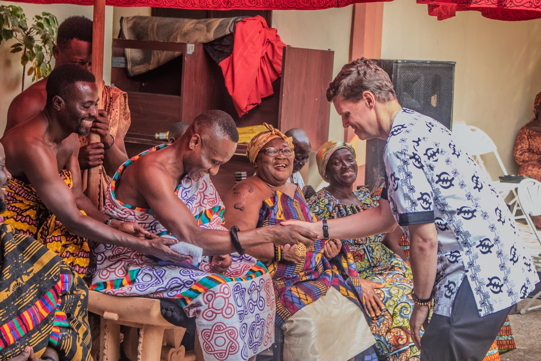 A visiting partner being received in handshake by chiefs and elders
